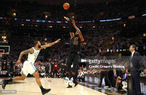 LeBron James of the Cleveland Cavaliers shoots against Marcus Morris of the Boston Celtics in the second quarter as head coach Brad Stevens of the...