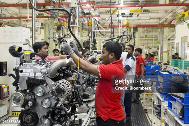 Employees assemble engines at the Mahindra & Mahindra Ltd. Facility in Chakan, Maharashtra, India, on Tuesday, April 3, 2018. Mahindra & Mahindra is...