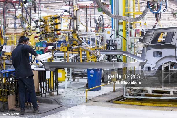 An employee assembles a door plate for a Mahindra & Mahindra Ltd. XUV 500 sport-utility vehicle on the production line at the company's facility in...
