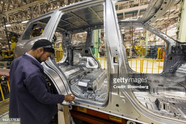 An employee inspects a Mahindra & Mahindra Ltd. XUV 500 sport-utility vehicle on the production line at the company's facility in Chakan,...