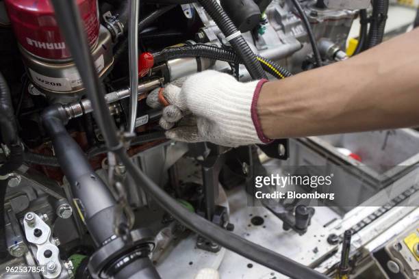 An employee assembles an engine at the Mahindra & Mahindra Ltd. Facility in Chakan, Maharashtra, India, on Tuesday, April 3, 2018. Mahindra &...