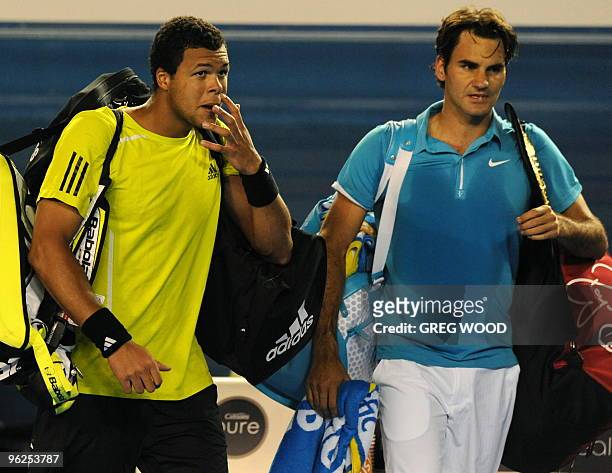 Swiss tennis player Roger Federer walks off the court with French opponent Jo-Wilfried Tsonga after victory in their men's singles semi-final match...