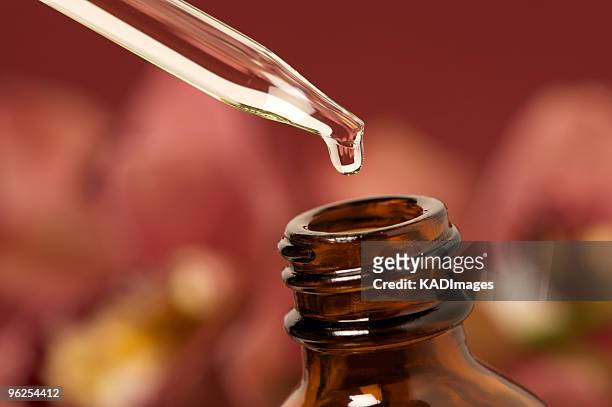 essential oils with dropper above bottle - aromatherapy oil stockfoto's en -beelden