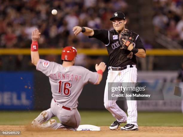Pat Valaika of the Colorado Rockies throws to first base after forcing out Tucker Barnhart of the Cincinnati Reds at second base on a double play in...