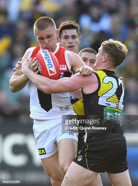 Sebastian Ross of the Saints is tackled by Josh Caddy of the Tigers during the round 10 AFL match between the Richmond Tigers and the St Kilda Saints...
