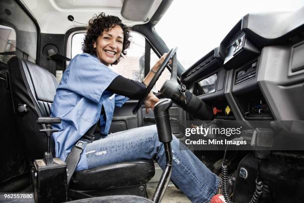 hispanic woman truck driver and company delivery truck. - trucker stock-fotos und bilder