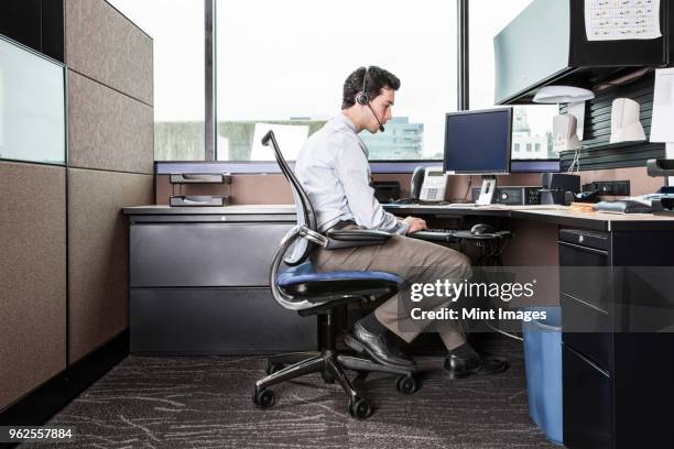 caucasian man working in an office cubicle. - cubicle foto e immagini stock