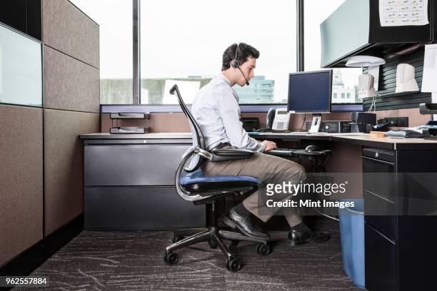 caucasian man working in an office cubicle. - cubicle wall stock pictures, royalty-free photos & images