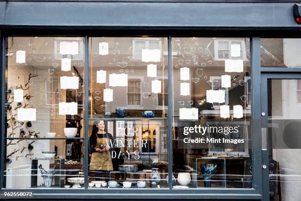 view through window into a pottery shop. - schaufenster stock-fotos und bilder