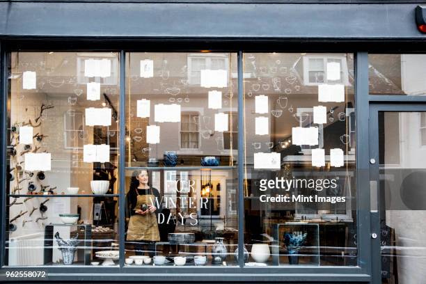 view through window into a pottery shop. - empty store window stockfoto's en -beelden