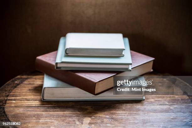 high angle close up of stack of book s on wooden table. - book table stockfoto's en -beelden