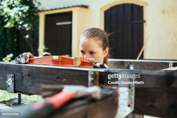 woman building garden deck using a level. - guido mieth 個照片及圖片檔