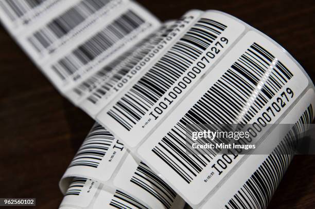 close up of a printed barcode label on a roll, packing and distributing goods in a distribution warehouse. - barcode bildbanksfoton och bilder