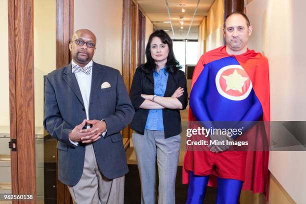 caucasian middle aged man super hero and his mixed race team staff in their office - super excited suit stock pictures, royalty-free photos & images