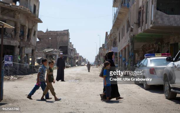 April 24: A woman and children cross a war-damaged street in the old town of Mosul on April 24, 2018 in MOSUL, IRAQ.