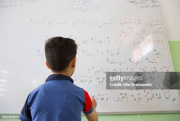 April 24: An Iraqi boy writes on a blackboard in the Al Huda School of UNICEF, a BMZ rehabilitated school in West Mosul on April 24, 2018 in MOSUL,...