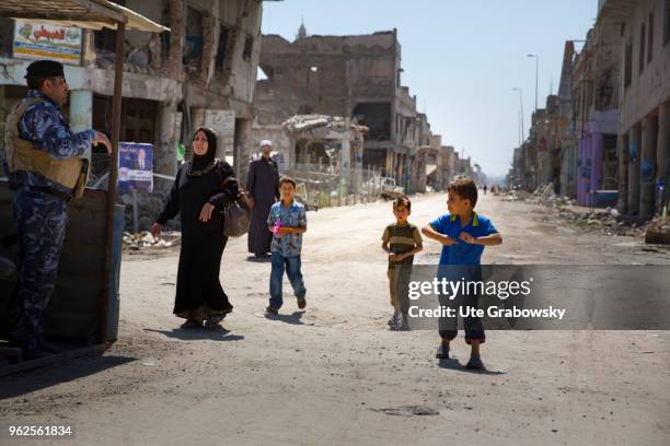 April 24: A woman and her children on a street in the destroyed old town in Mosul on April 24, 2018 in MOSUL, IRAQ.