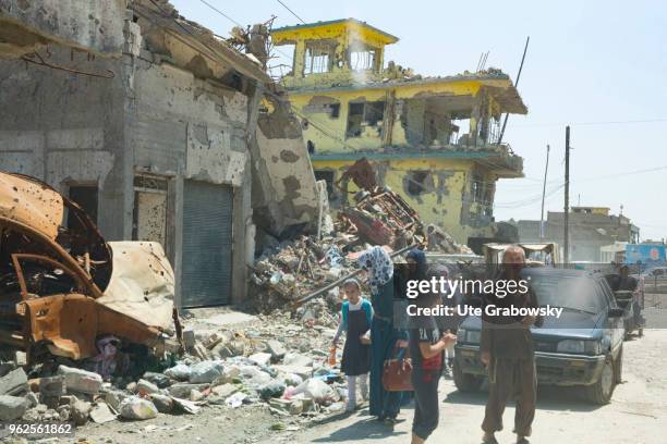 April 24: People on a street in front of ruins in the destroyed old town in Mosul on April 24, 2018 in MOSUL, IRAQ.