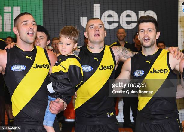 Shaun Grigg, Dustin Martin and Trent Cotchin of the Tigers sing the song in the rooms after winning the round 10 AFL match between the Richmond...