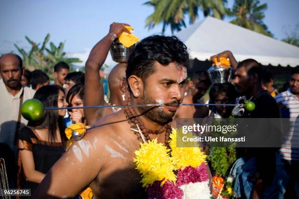 Hindu devotee is pierced with hooks in his tongue and cheeks, before making his way towards the Batu Caves temple during the Thaipusam Hindu festival...