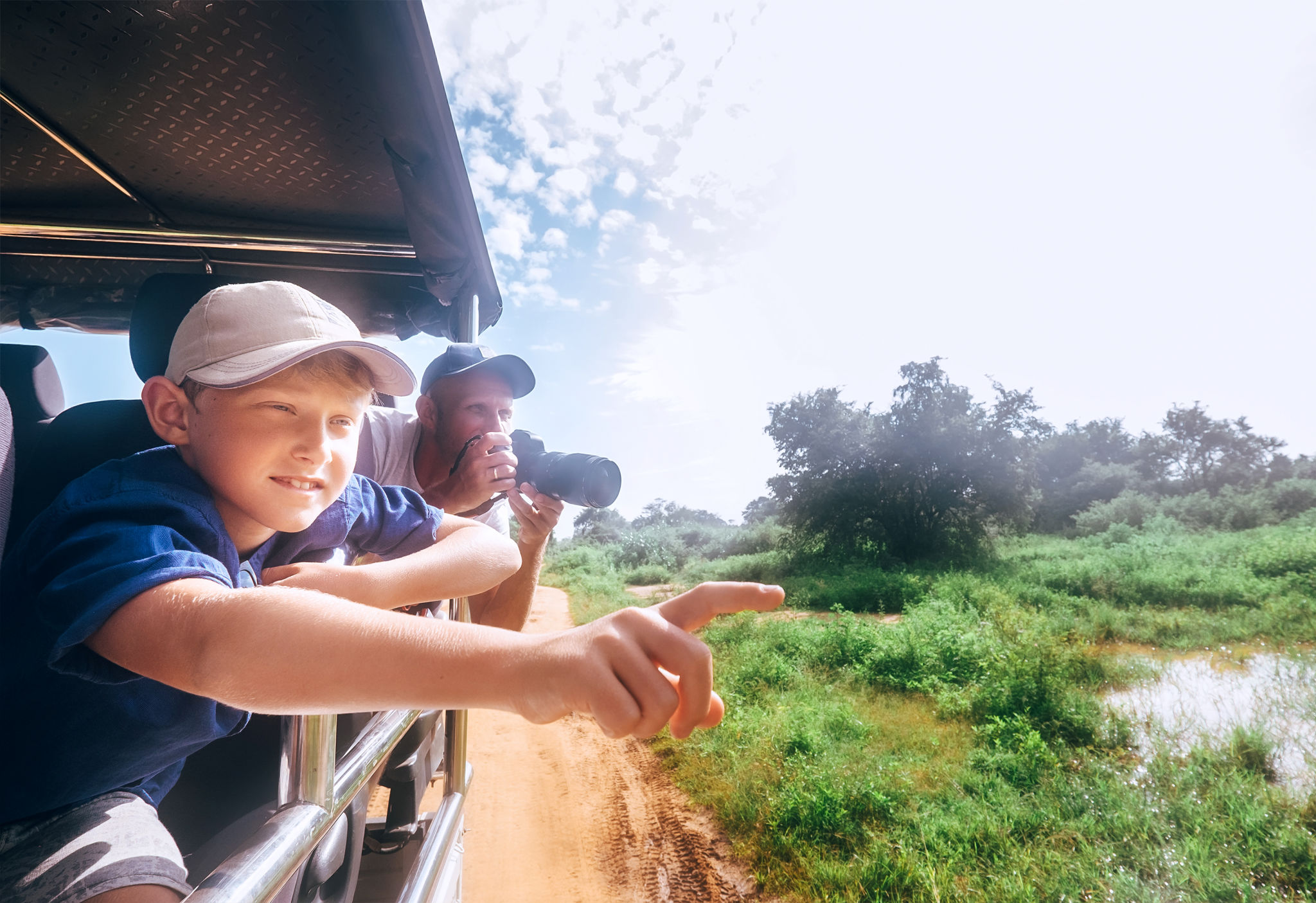 Son and father saw the animals on safari in nature park Son and father saw the animals on safari in nature park