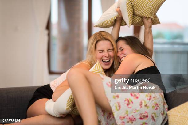 fun loving sisters quarreling with cushions - coussin photos et images de collection