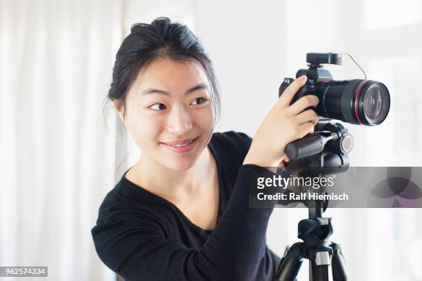 smiling young woman photographing with camera - ralf hiemisch fotografías e imágenes de stock
