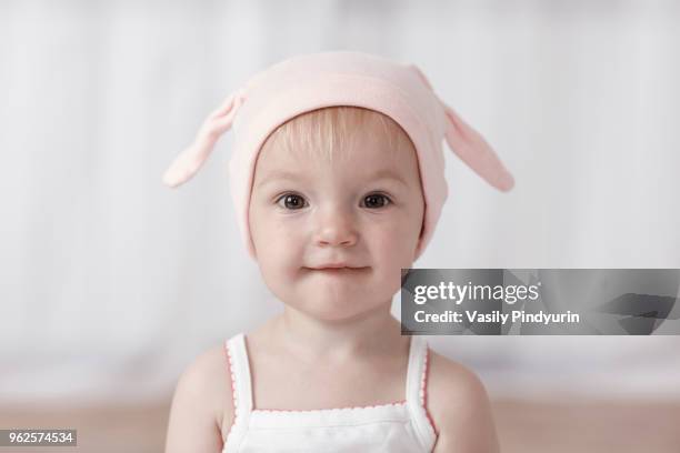 close-up portrait of cute baby girl wearing headwear at home - pindyurin stock-fotos und bilder