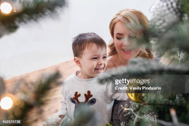 high angle view of cheerful decorating christmas tree with mother at home - pindyurin stock-fotos und bilder
