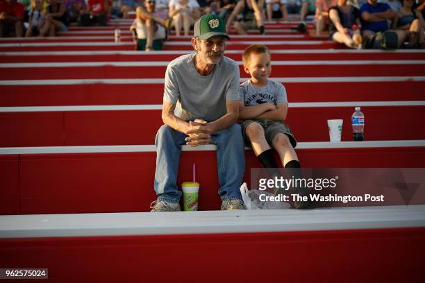Charlie Doss, of Chase City, VA, sits in the stands with his grandson Tucker Doss as clean up crews work on a wreck right in front of them during the...