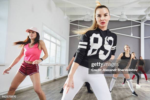confident young female in sports clothing dancing at studio - hip hop dance fotografías e imágenes de stock