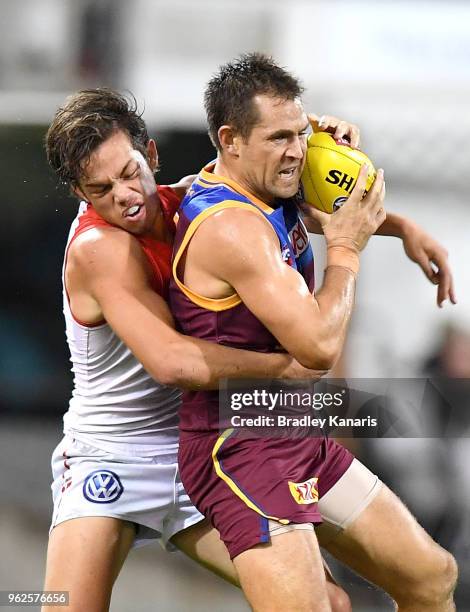 Luke Hodge of the Lions is pressured by the defence of Oliver Florent of the Swans during the round 10 AFL match between the Brisbane Lions and the...