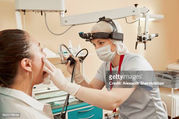 doctor using equipment while examining female patient at hospital - endoscope stock pictures, royalty-free photos & images
