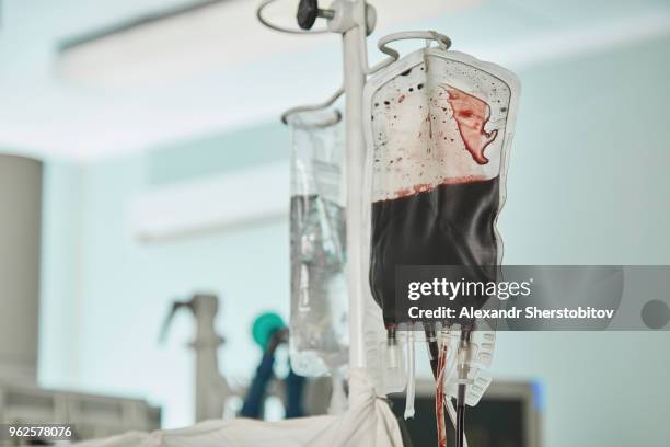 close-up of blood bag hanging in hospital ward - blood bag stock-fotos und bilder