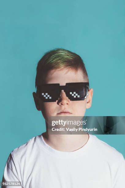 boy wearing sunglasses against blue background - pindyurin foto e immagini stock
