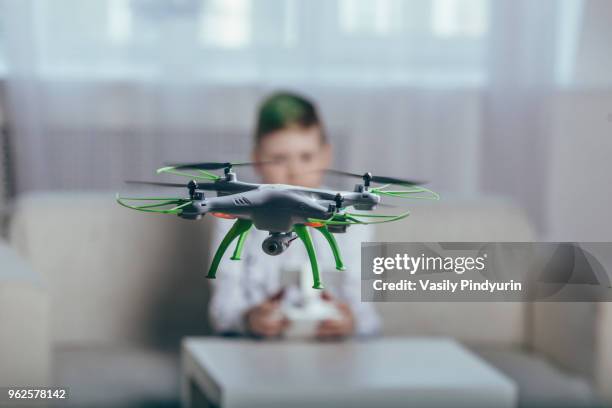 boy flying drone in living room at home - pindyurin stock-fotos und bilder