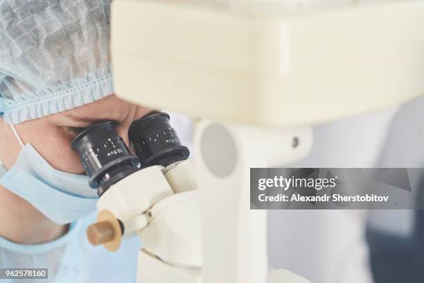 surgeon using medical equipment during eye surgery - sherstobitov stock pictures, royalty-free photos & images