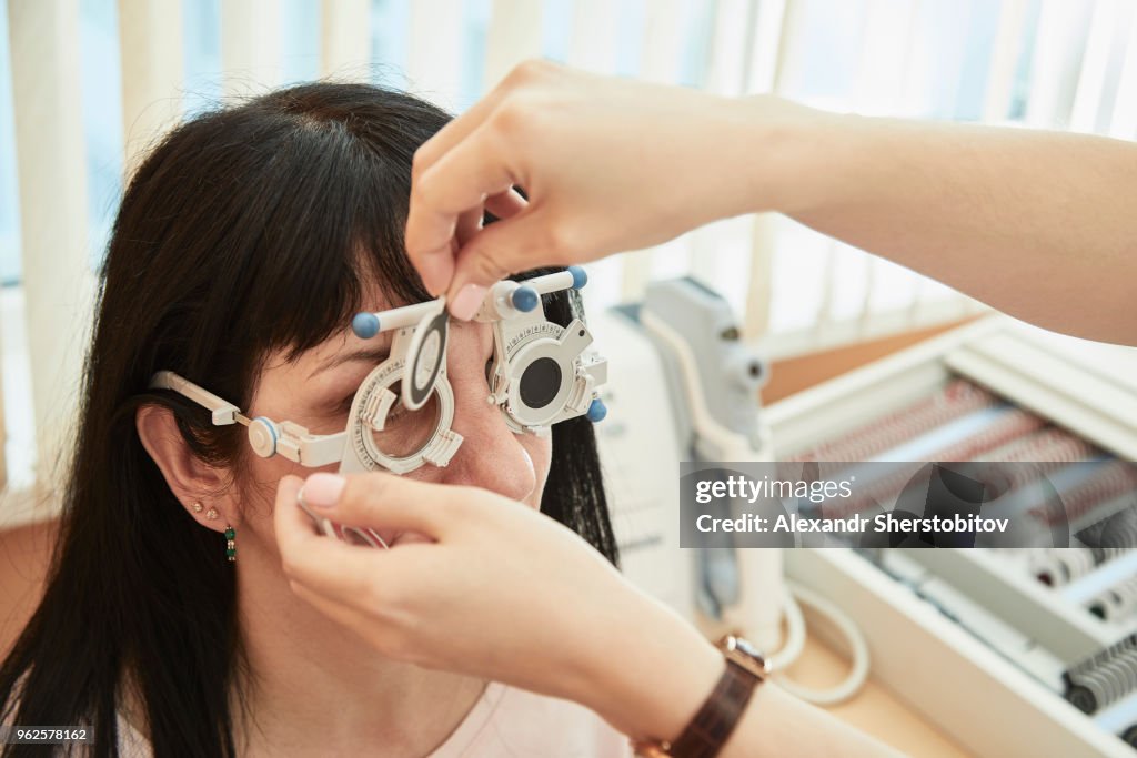 Cropped image of optometrist examining woman's vision at clinic