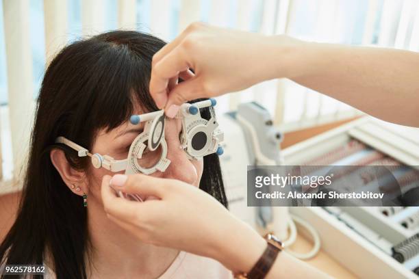 cropped image of optometrist examining woman's vision at clinic - sherstobitov stock pictures, royalty-free photos & images