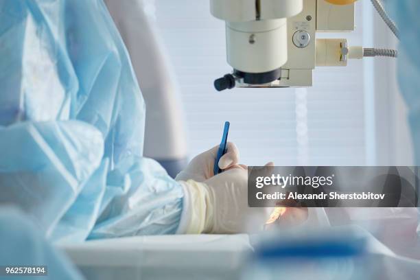 midsection of surgeon performing eye surgery on patient in operating room - microchirurgie stockfoto's en -beelden