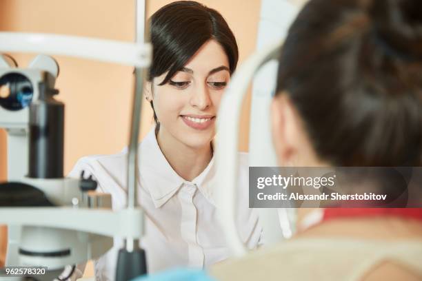 smiling young doctor examining patient at hospital - sherstobitov stock pictures, royalty-free photos & images