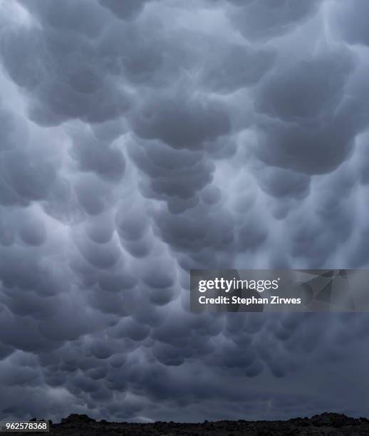 low angle view of mammatus clouds in sky, iceland - mammatus cloud stock pictures, royalty-free photos & images