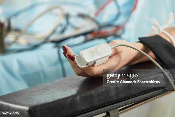 cropped image of patient wearing pulse oxymeter while lying on bed at hospital - sherstobitov stock pictures, royalty-free photos & images