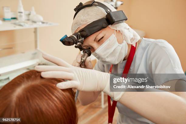 surgeon examining female patient while using equipment at hospital - sherstobitov stock pictures, royalty-free photos & images