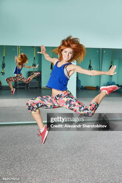 full length portrait of young woman jumping in mid-air at health club - sherstobitov stock pictures, royalty-free photos & images