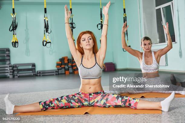 determined women practicing yoga on mats at health club - sherstobitov stock pictures, royalty-free photos & images