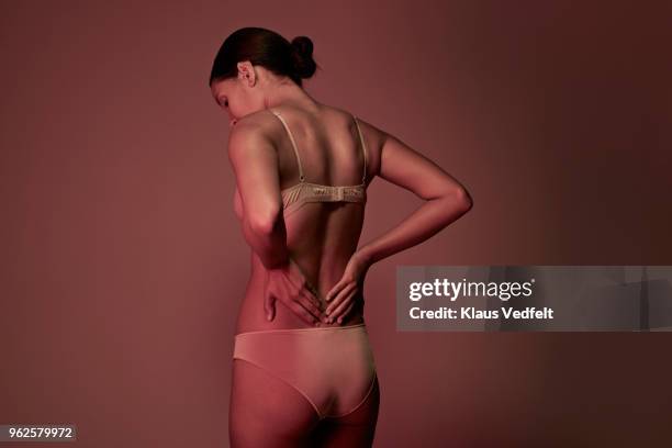 rear view of woman having back pain - female backside fotografías e imágenes de stock