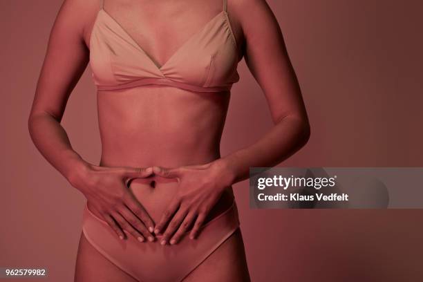 young woman having stomach ache - femme main ventre photos et images de collection