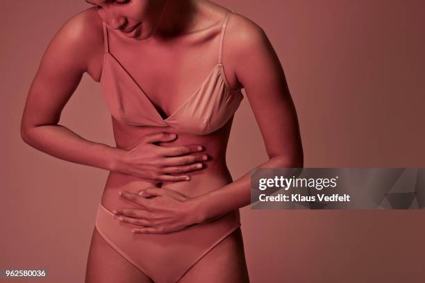 young woman having stomach ache - rumpf stock-fotos und bilder
