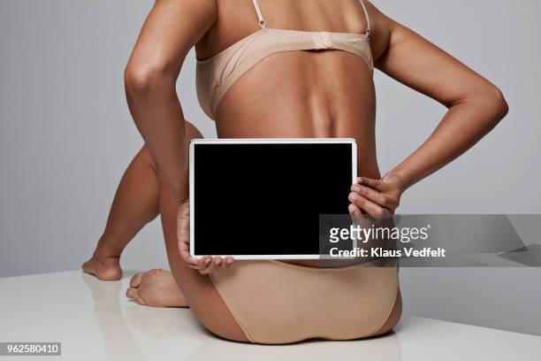 woman holding tablet in front of her back - female body parts bildbanksfoton och bilder